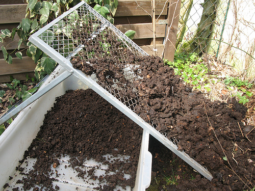 Sieving the compost with a coarse sieve by Sustainable sanitation garden soil photo